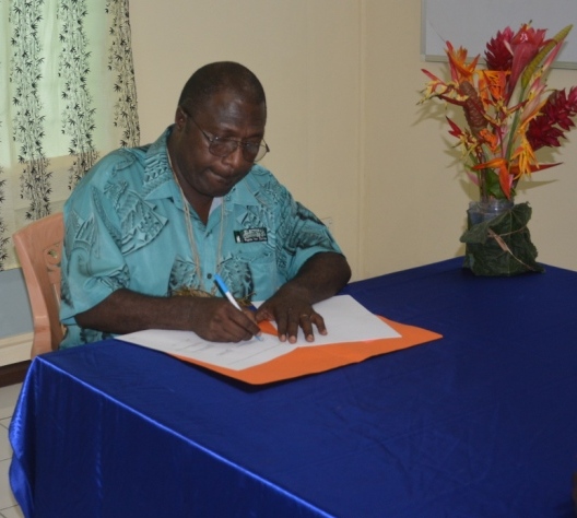 PNG Electoral Commissioner Patilias Gamato signing the MOU in Buka last week.